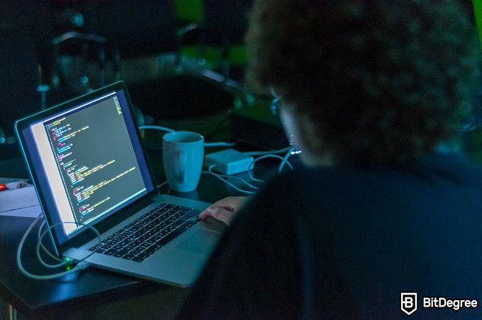Bursa Terdesentralisasi Terbaik: seorang peretas memasukkan kode ke sebuah laptop.
