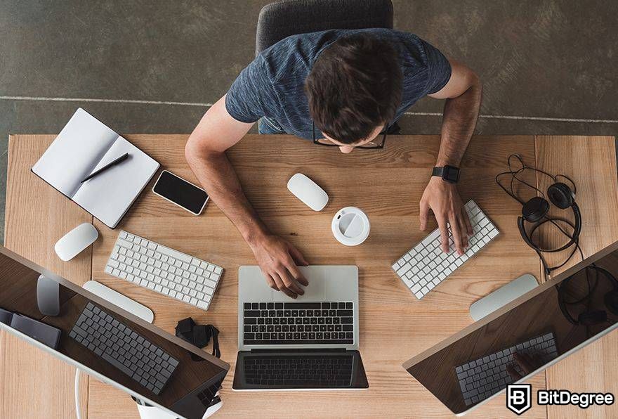 Metaverse business opportunities: man using three screens to work.
