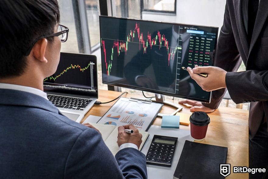 Reksadana crypto: seorang pria sedang mengajari temannya cara berinvestasi.