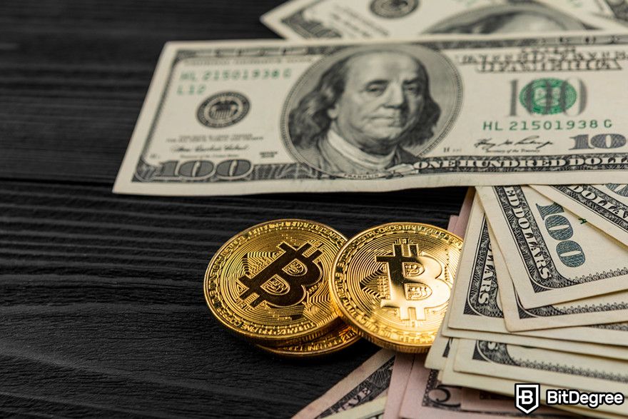 Cách short crypto: Đồng xu Bitcoin trên tờ đô la Mỹ trên bề mặt tối.