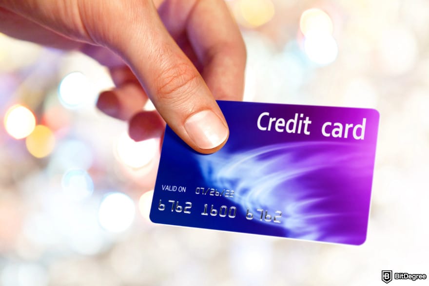 How to turn crypto into cash: a person holding a credit card.
